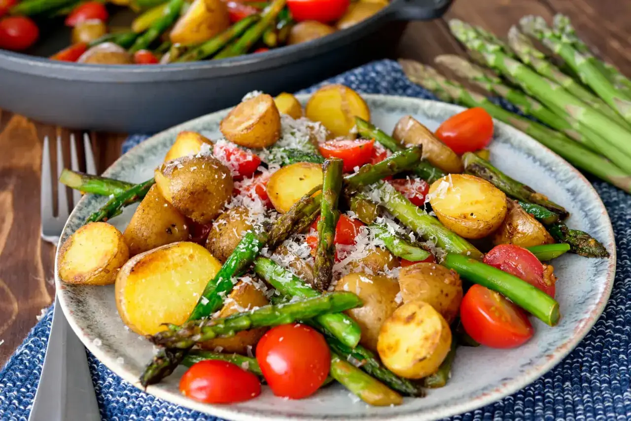 Ger&ouml;steter Spargel mit Kartoffeln und Tomaten, bestreut mit Parmesan. Ein k&ouml;stliches Gericht, das den Fr&uuml;hling auf den Teller bringt.