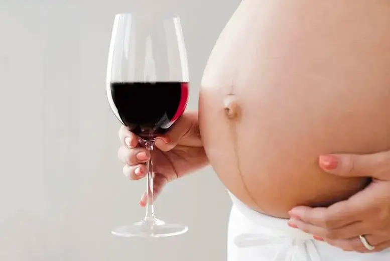 matka karmiąca z kieliszkiem wina