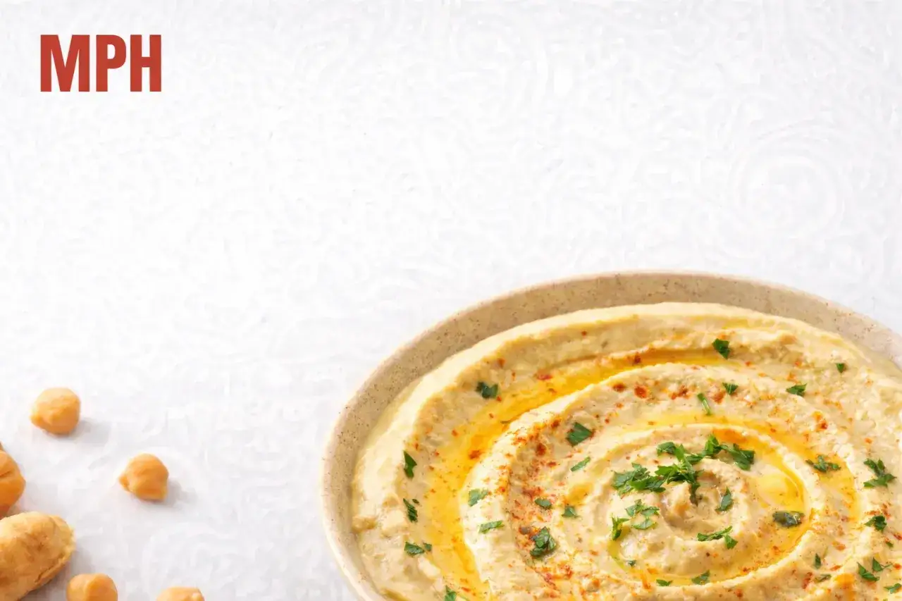 Pyszny hummus w misce, posypany papryką i pietruszką. Czy hummus jest zdrowy? Tak, to świetna przekąska!