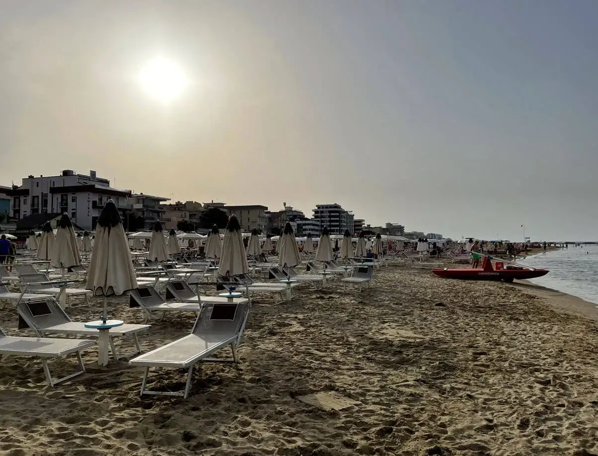 Spiaggia di Igea Marina con lettini e ombrelloni chiusi, bagnino pronto sul mare.