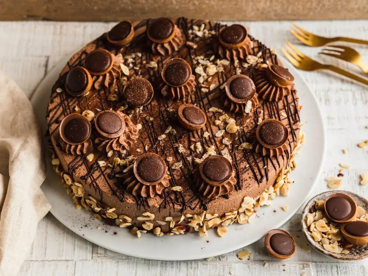 Eine köstliche Schokoladen-Toffifee-Torte, verziert mit Toffifee-Pralinen, Schokostreuseln und gehackten Nüssen.