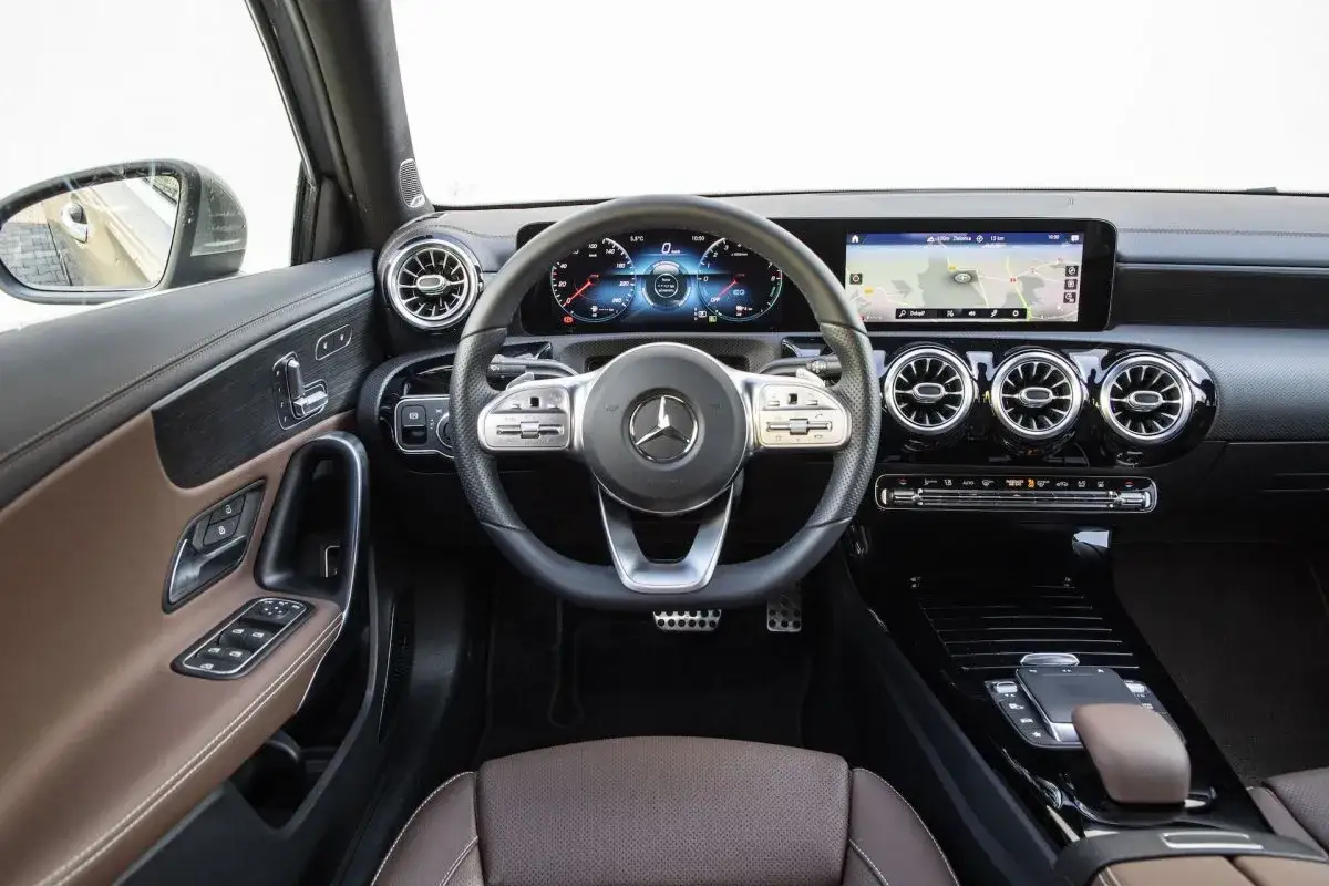 Wnętrze Mercedesa A250 z brązową tapicerką, nowoczesnym kokpitem i ekranem nawigacji.