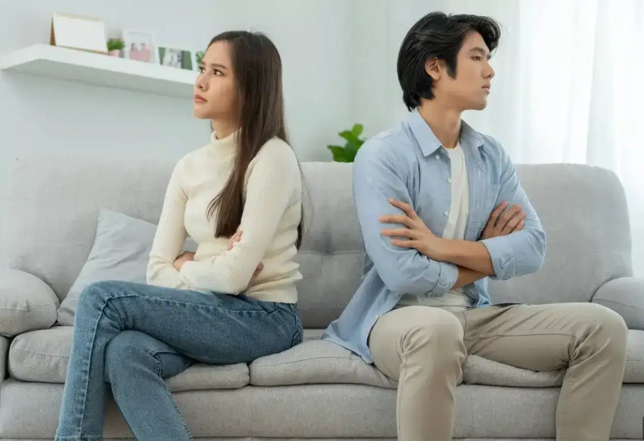 Pareja sentada en un sof&aacute;, d&aacute;ndose la espalda. Ella, con gesto de decepci&oacute;n, &eacute;l, con brazos cruzados. Es la sensaci&oacute;n de cuando esperas algo de alguien y no llega.