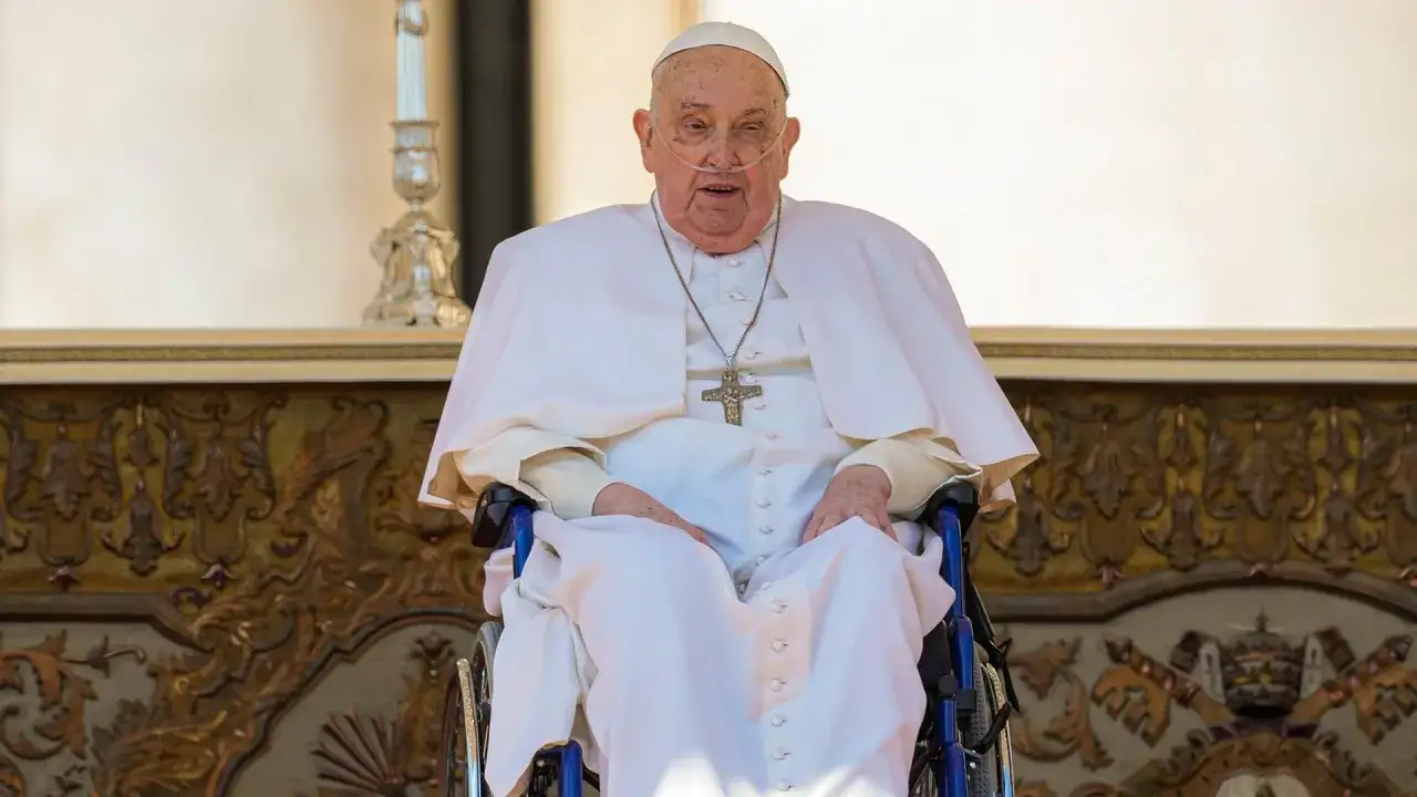 Papst Franziskus im Rollstuhl, seit wann ist Franziskus Papst? Er tr&auml;gt seine Soutane und ein Kreuz.