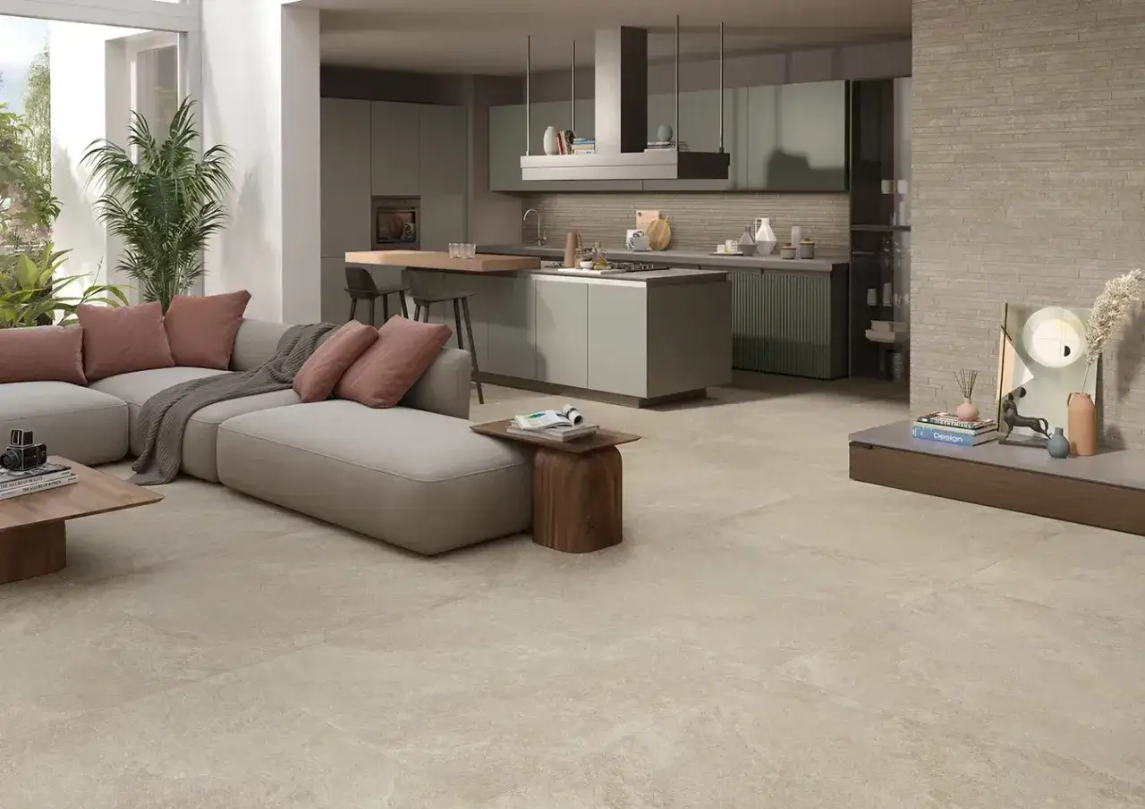 Soggiorno moderno con divano grigio, cucina a vista e un nuovo pavimento che trasforma l'ambiente.