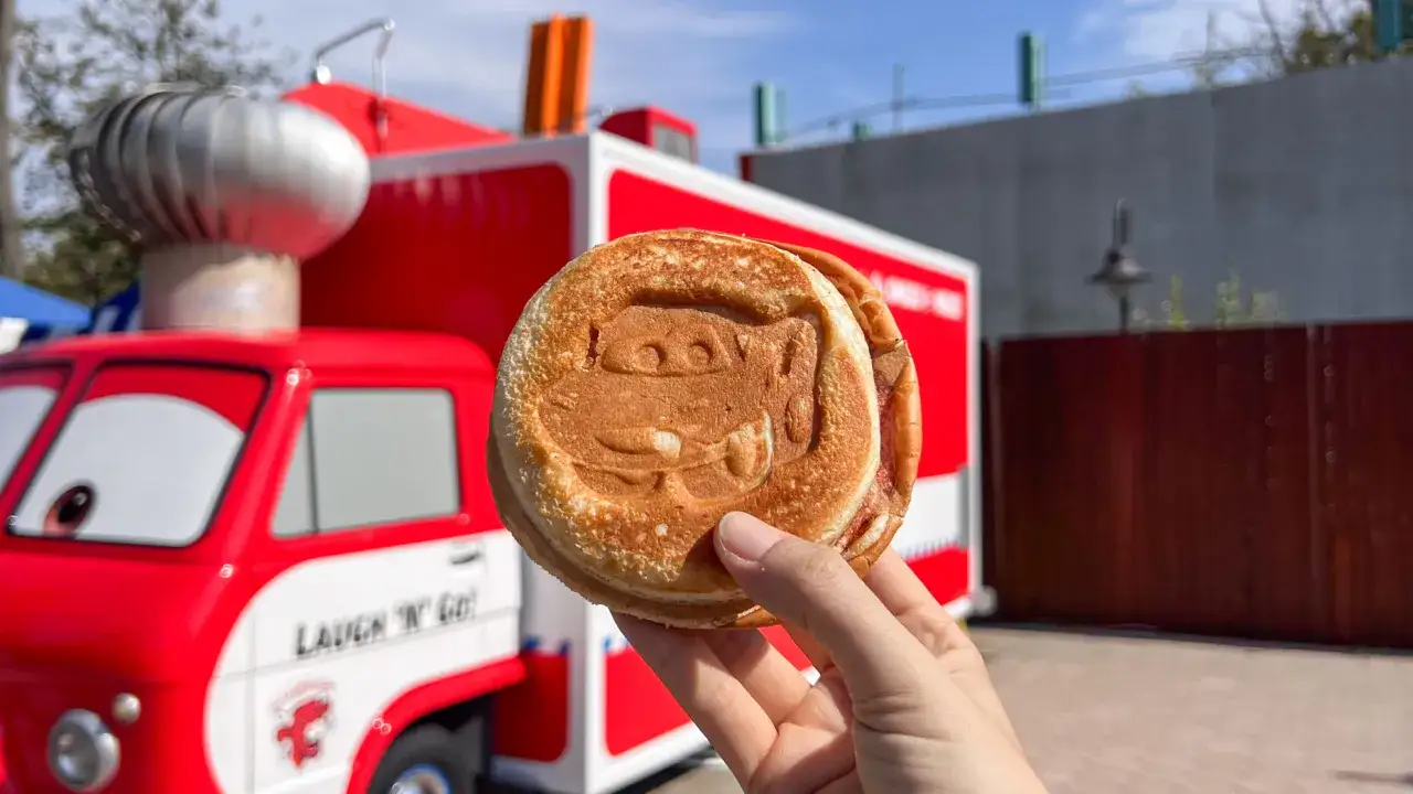 Leckeres Essen zum Mitnehmen im Disneyland Paris: Ein Pfannkuchen mit Lightning McQueen-Gesicht vor einem roten