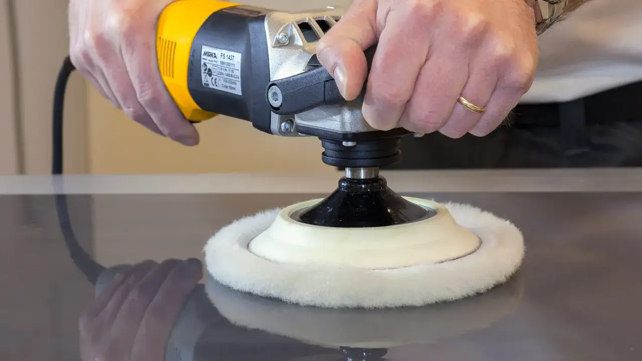 Polissage d'un meuble en bois verni avec une lustreuse. La surface devient lisse et brillante.