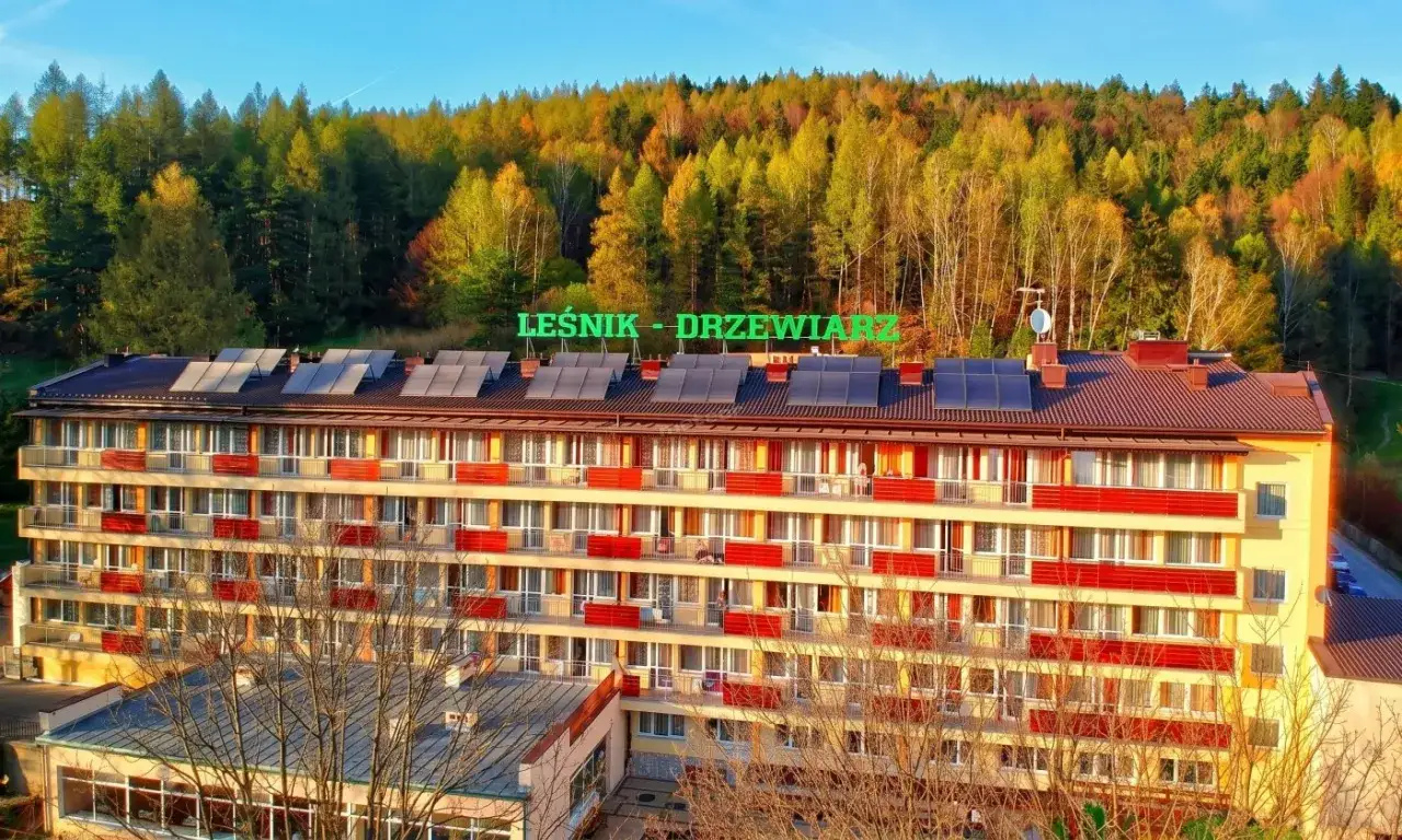 Hotel Leśnik-Drzewiarz w Krynicy, otoczony jesiennym lasem.
