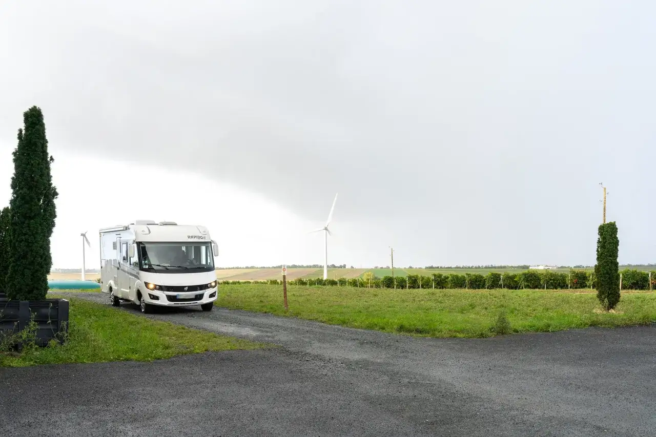 Camping-car Rapido en France, un avis sur la liberté de voyager. Paysage rural avec éolienne et vignes.