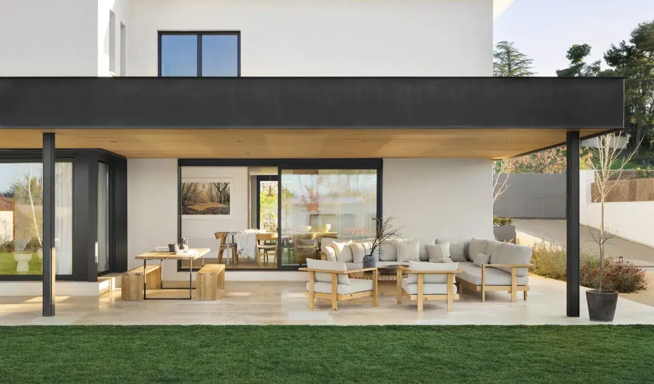 Porches sencillos y bonitos con mobiliario de madera y cojines claros, ideales para disfrutar del exterior.