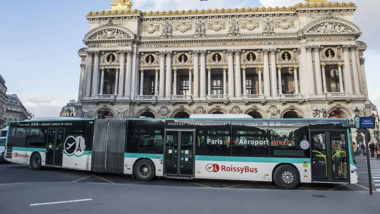 Un bus RoissyBus, reliant Paris à l'aéroport Charles de Gaulle, est garé devant l'Opéra Garnier.