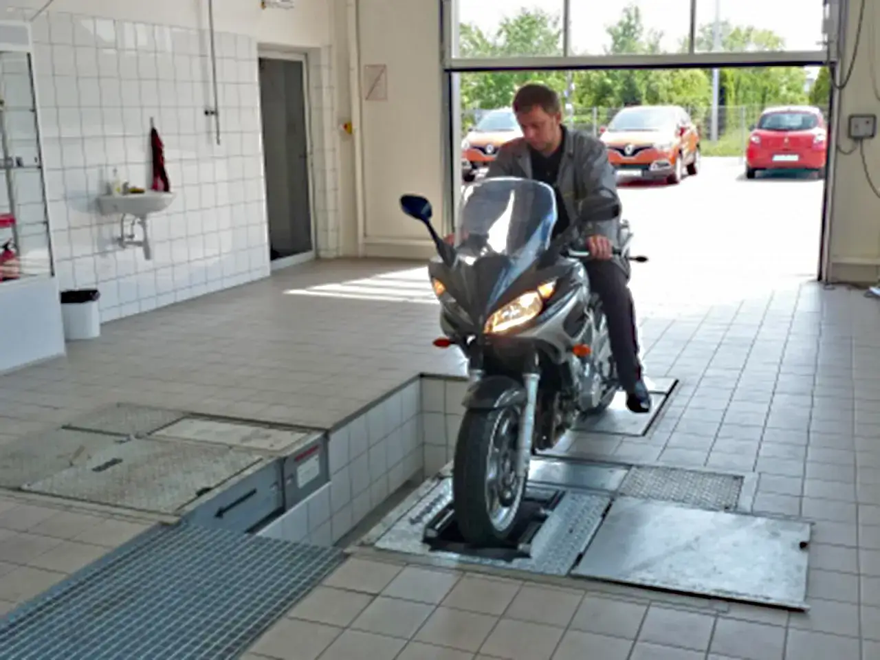 Mechanik na motocyklu w warsztacie. Zastanawiasz się, ile kosztuje przegląd motocykla?