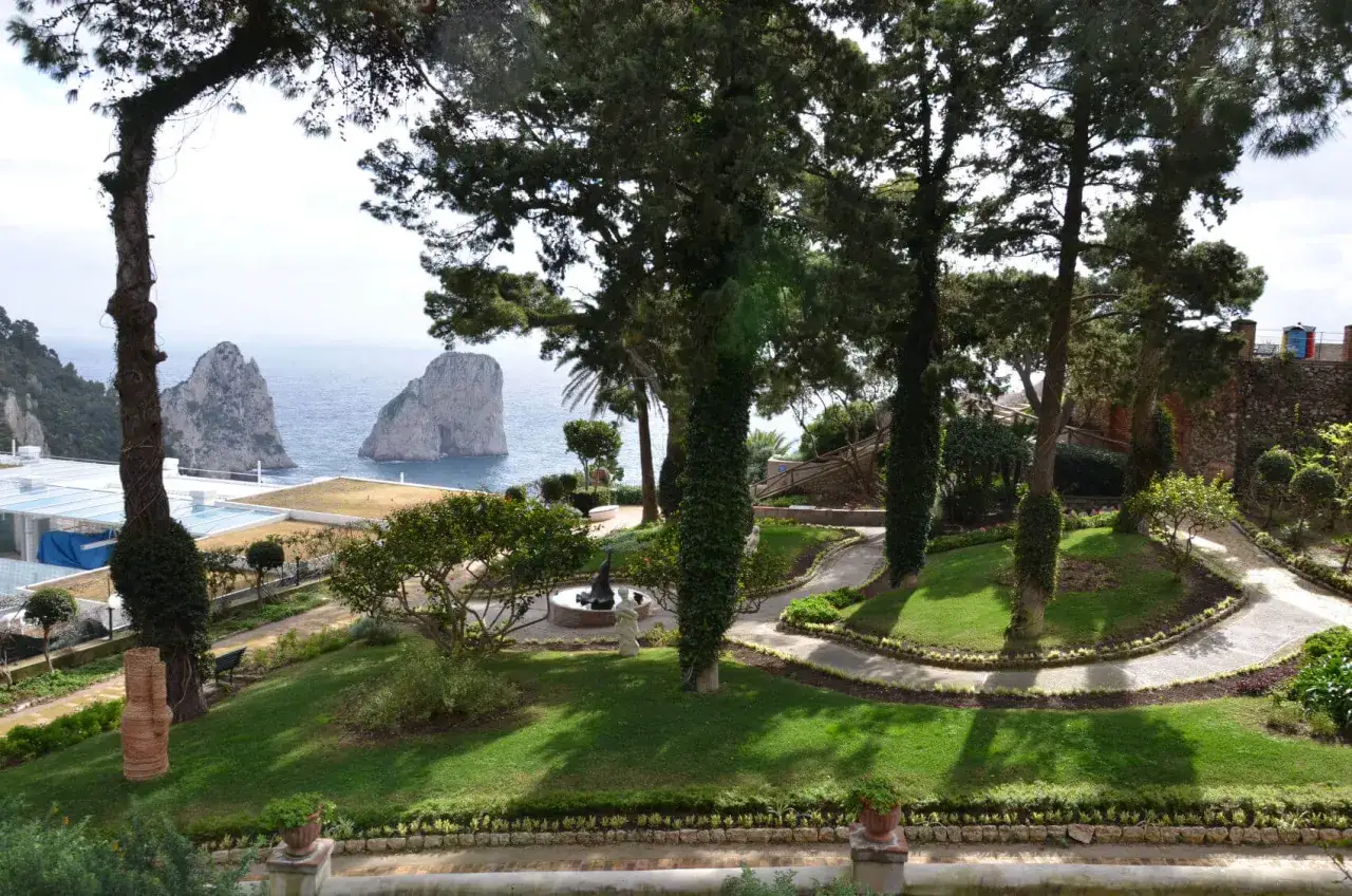 Giardini lussureggianti con sentieri tortuosi e i Faraglioni sullo sfondo, un assaggio delle cose da vedere a Capri.