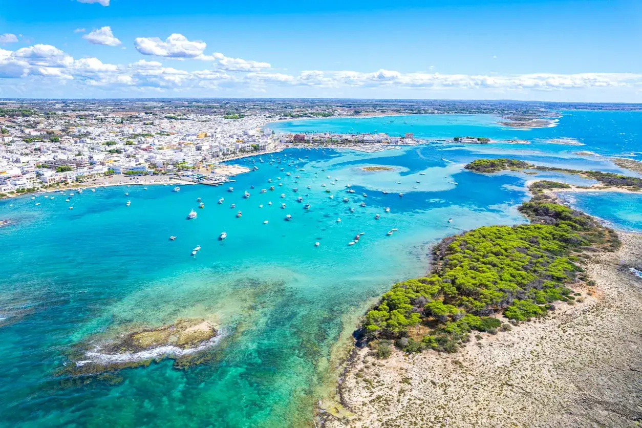 Baia con acque cristalline e un borgo bianco, un vero gioiello tra i posti da visitare in Puglia.
