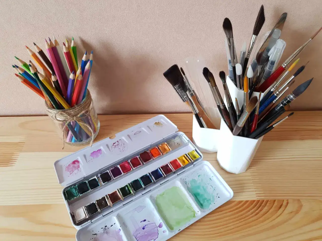 Palette d'aquarelle ouverte, crayons de couleur et pinceaux. Id&eacute;al pour apprendre comment utiliser de l'aquarelle et cr&eacute;er des &oelig;uvres vibrantes.