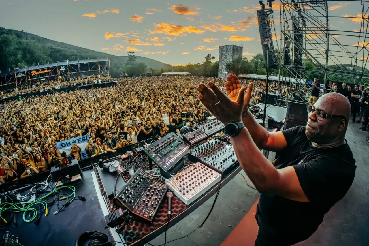 Le meilleur DJ du monde, Carl Cox, enflamme la foule immense lors d'un festival au coucher du soleil.
