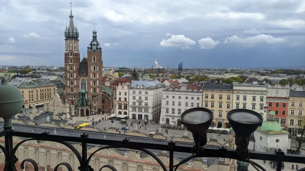 Widok na Rynek Gł&oacute;wny w Krakowie z dominującą wieżą ratuszową i Sukiennicami.