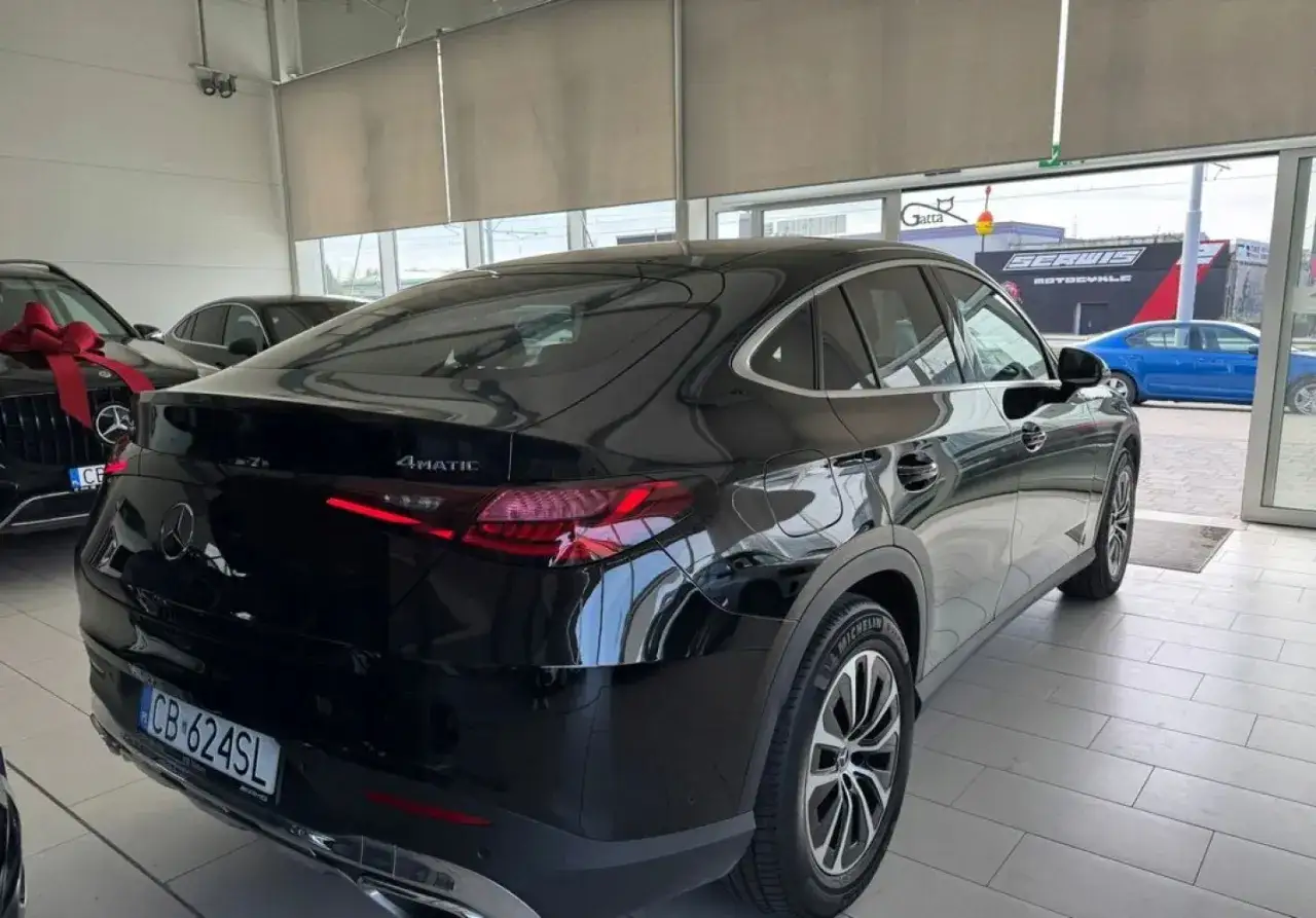 Czarny, używany Mercedes GLC 4Matic z salonu, z eleganckimi felgami i sportową sylwetką coupe.