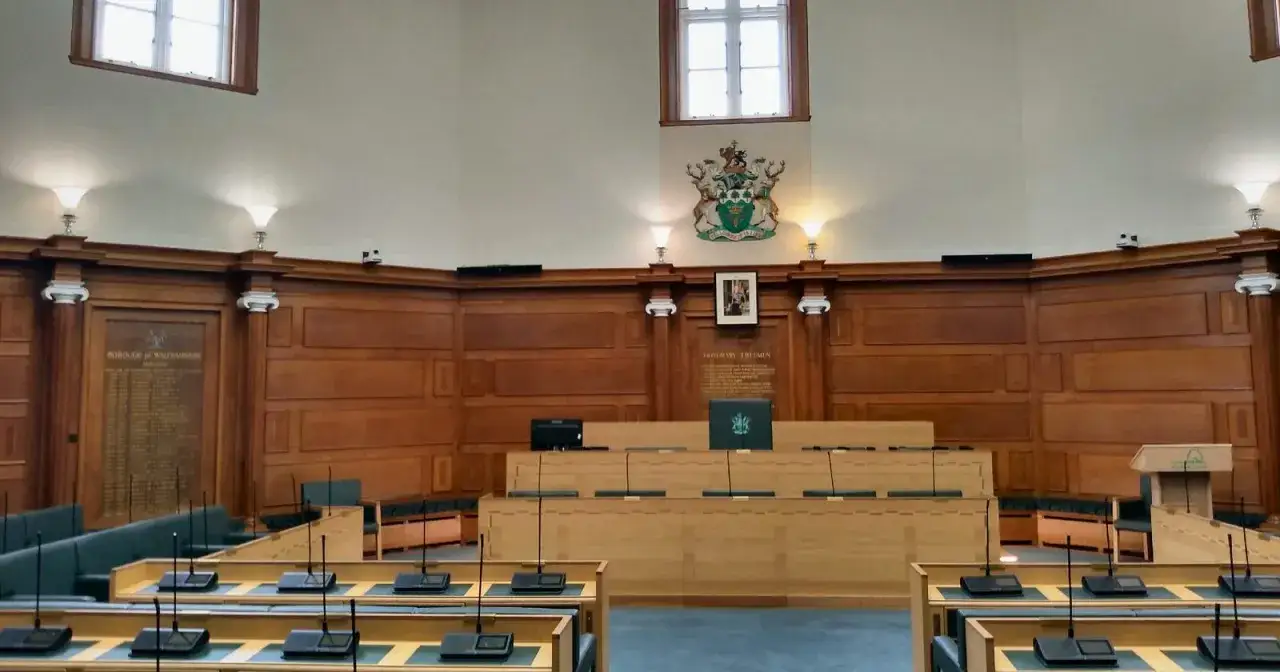 Sala posiedzeń z drewnianymi panelami, miejscami dla członków rady nadzorczej i mównicą.
