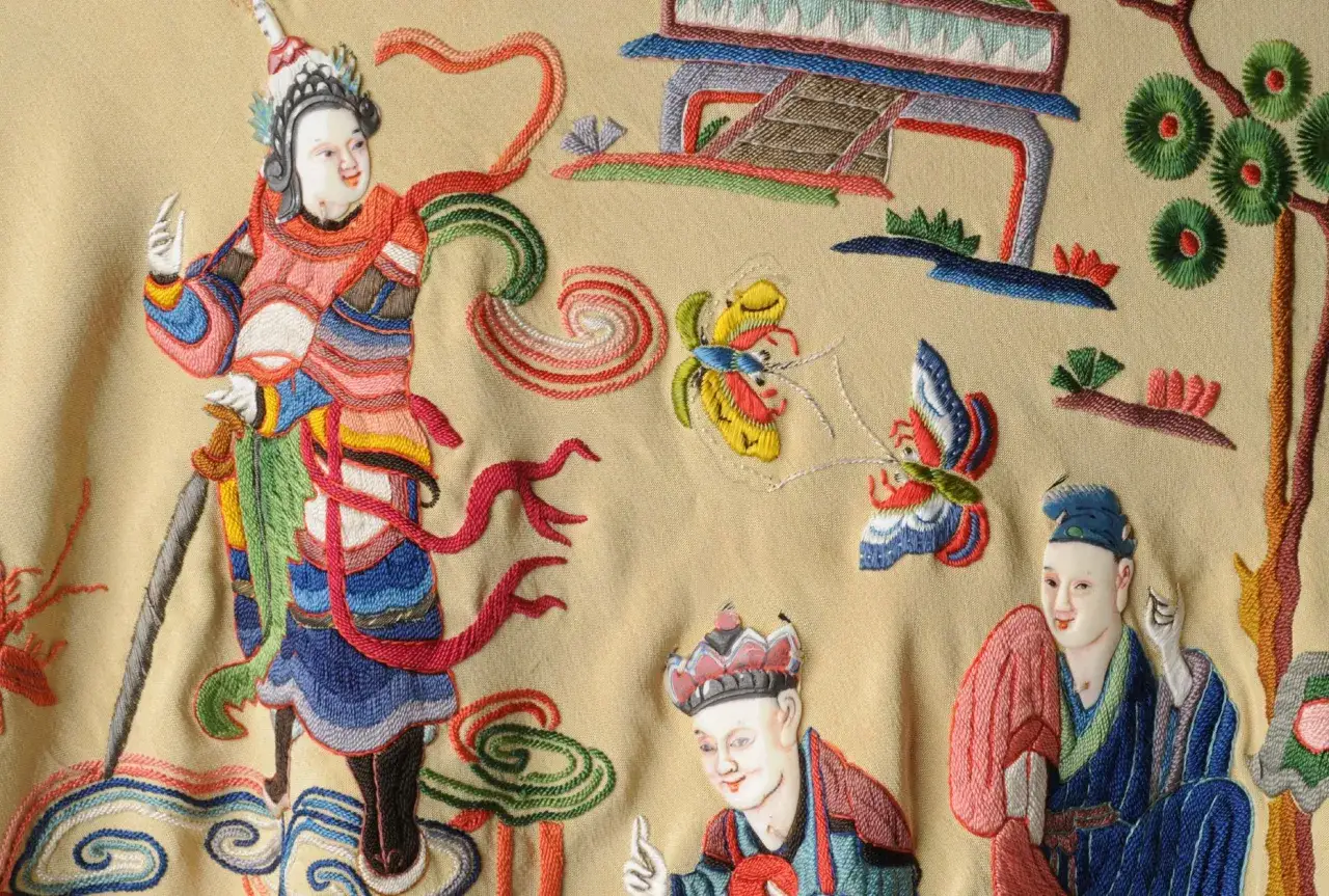Detalle de un mant&oacute;n de Manila con bordados de figuras chinas, mariposas y arquitectura.