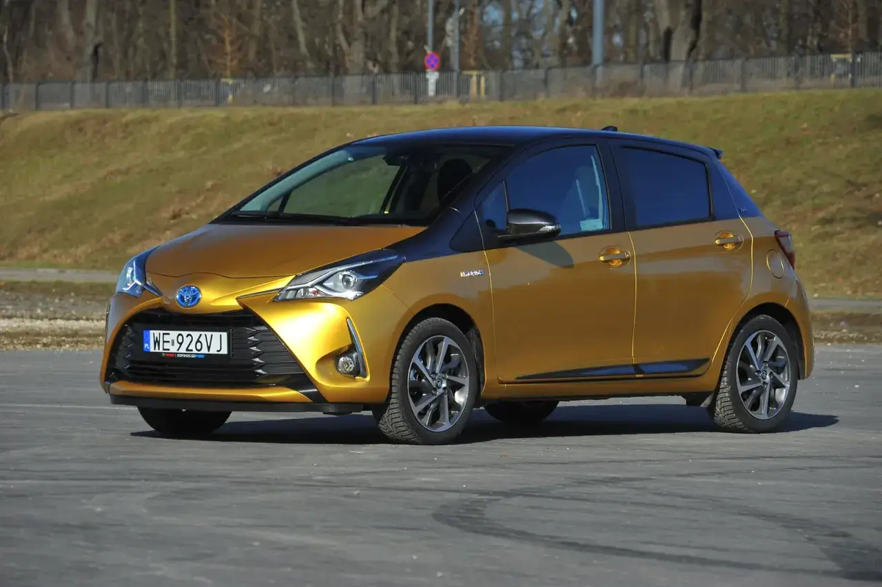 Złoty Toyota Yaris Hybrid z czarnym dachem, idealny do miasta. Sprawdź jego wymiary!