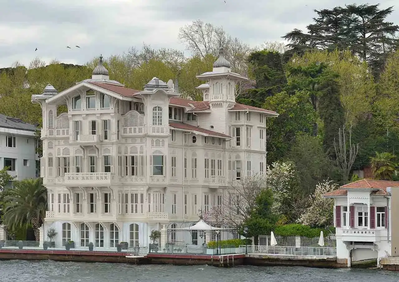 Una mansi&oacute;n blanca de estilo otomano junto al B&oacute;sforo, rodeada de &aacute;rboles verdes. &iexcl;Estambul fotos bonitas!