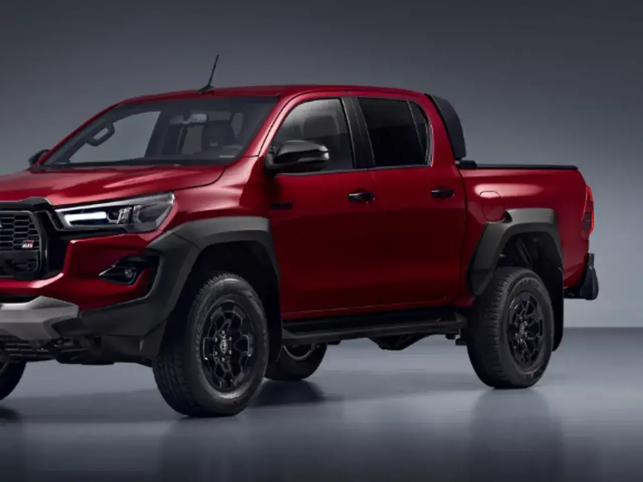 Czerwony Toyota Hilux GR Sport z czarnymi dodatkami, gotowy na każdą przygodę.