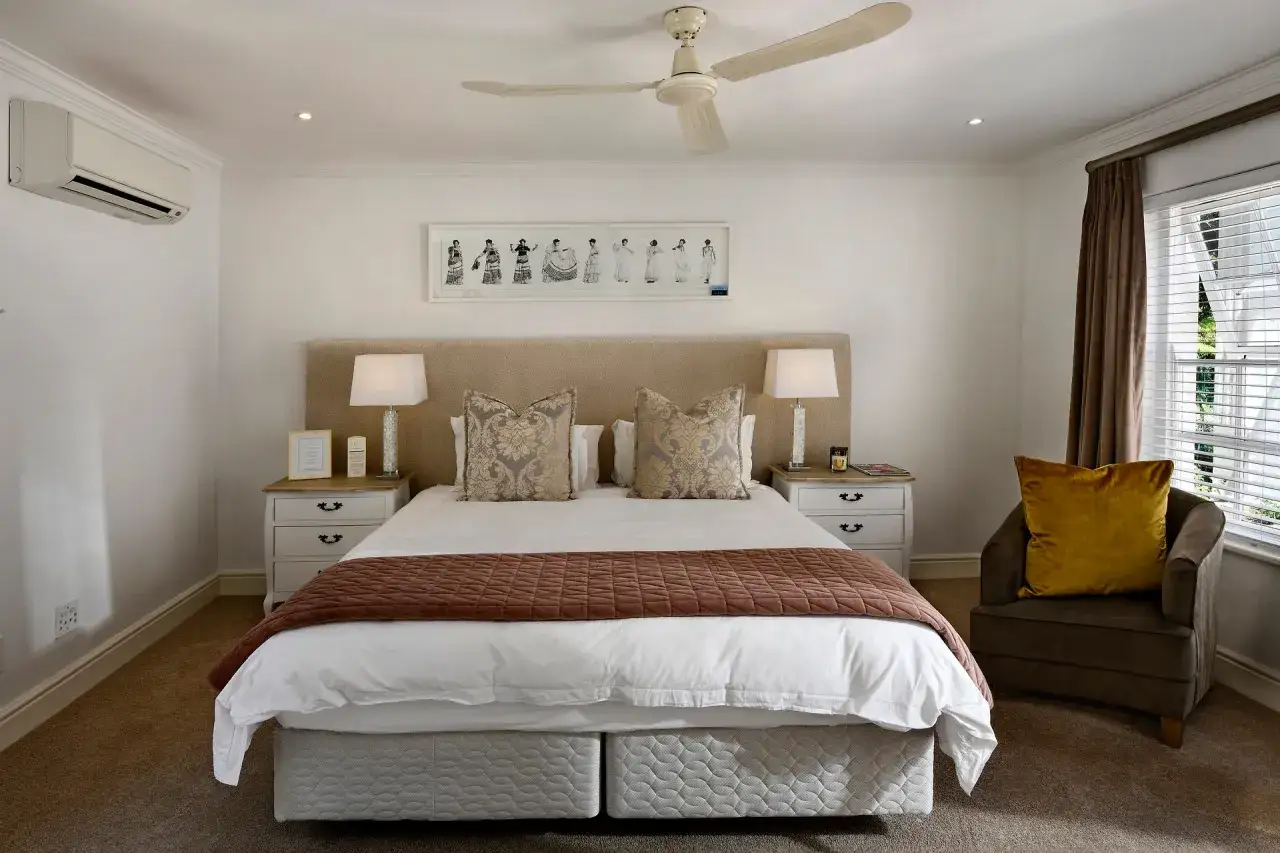 Luxurious hotel bedding layers, featuring crisp white sheets, decorative pillows, and a warm throw, invite a restful night's sleep.