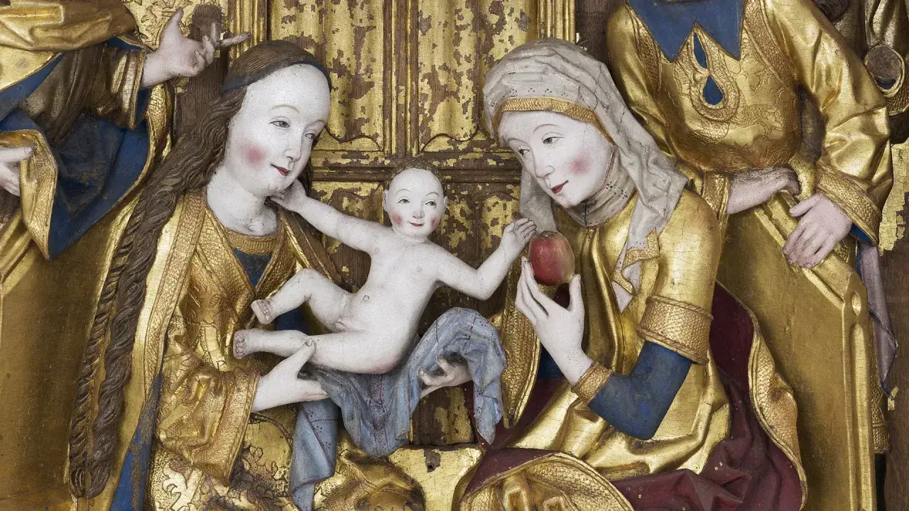 En gyllene skulptur visar jungfru Maria med Jesusbarnet. En annan kvinna, m&ouml;jligen jungfru Marias moder, h&aring;ller ett &auml;pple.