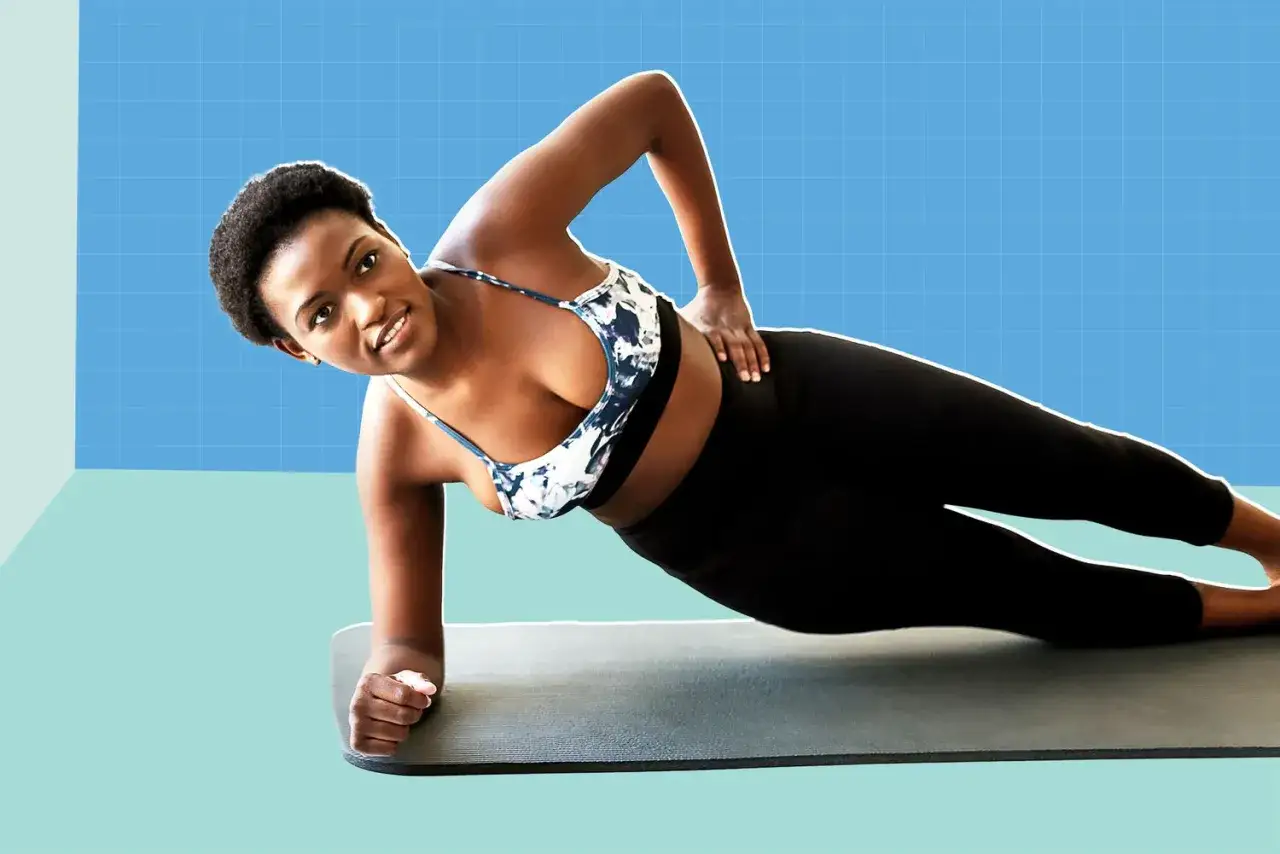 Mujer haciendo plancha lateral, un ejercicio clave para el déficit calórico y perder grasa abdominal.