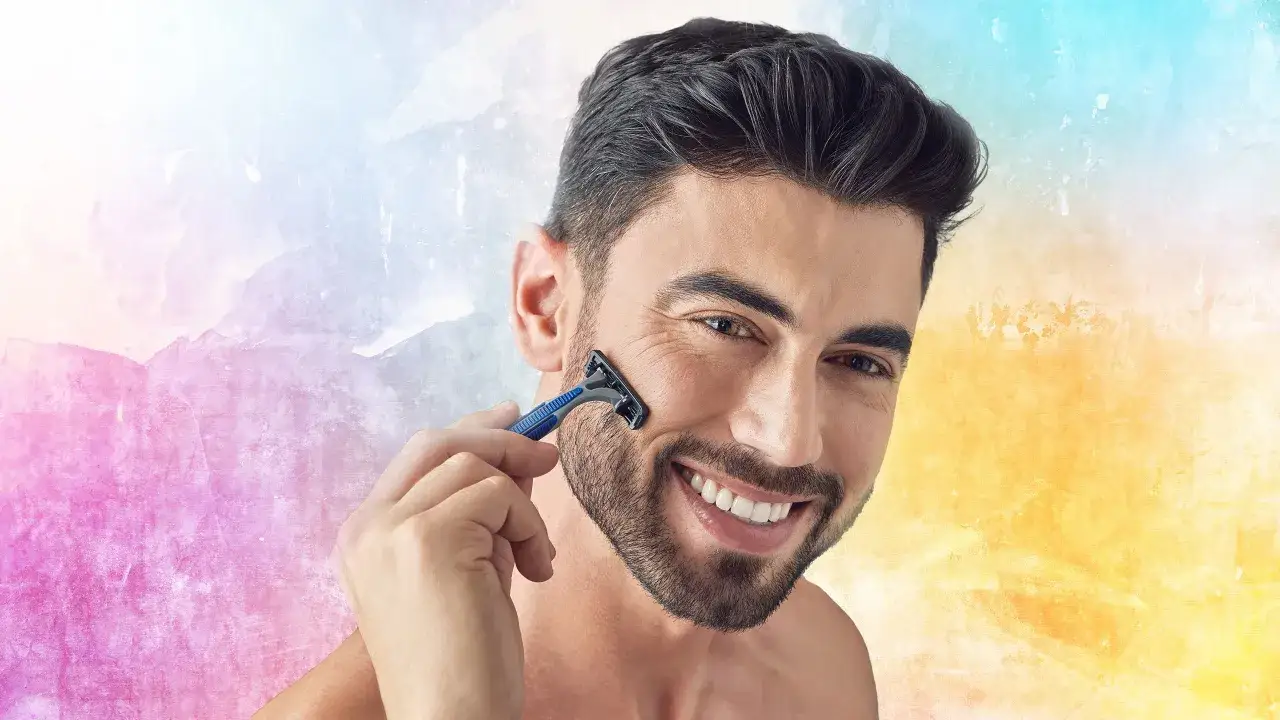 Un homme souriant se rase le visage, sa barbe de 3mm est presque parfaite.