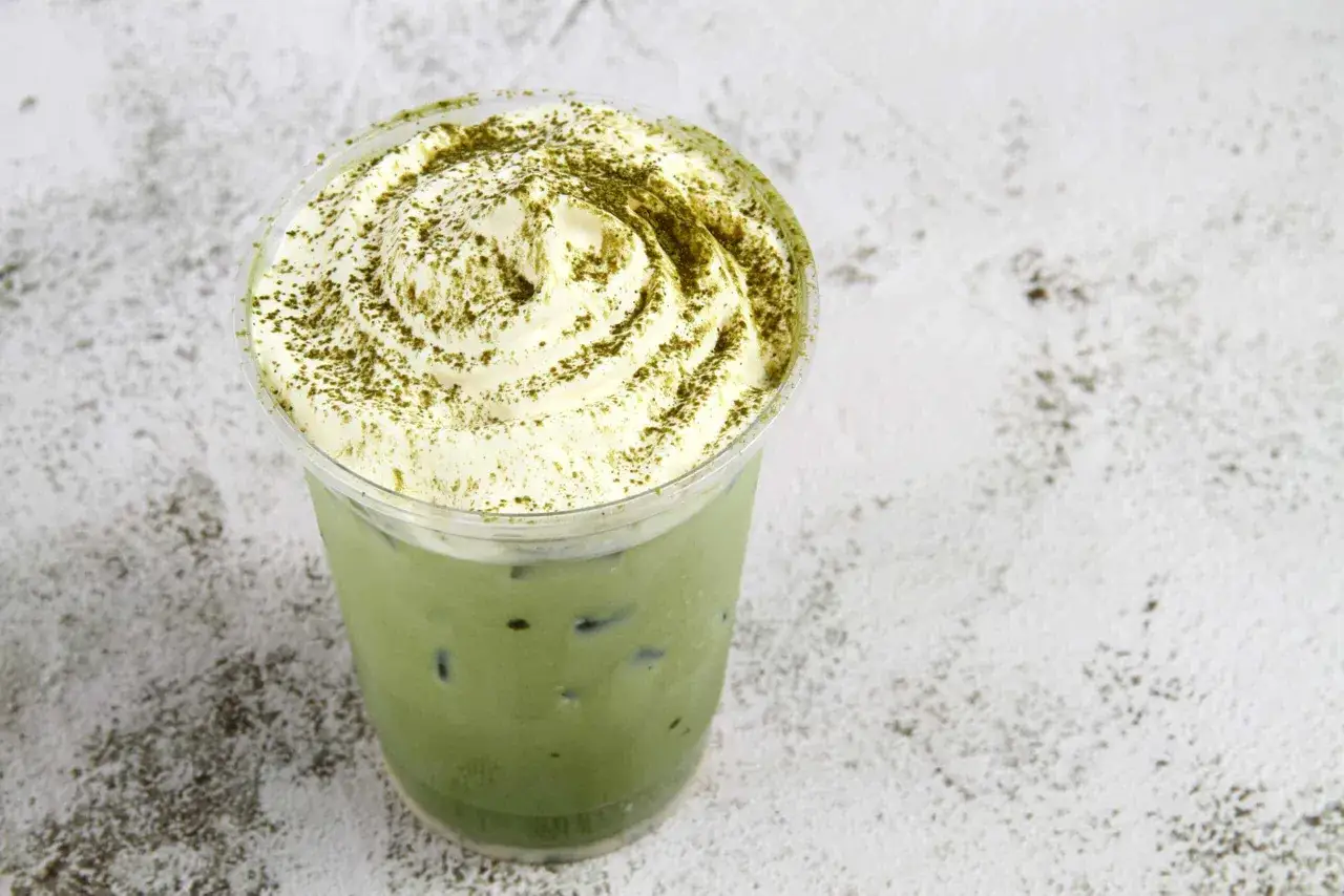 Mrożona zielona herbata z bitą śmietaną i posypką matcha. Odkryj jej orzeźwiające właściwości!
