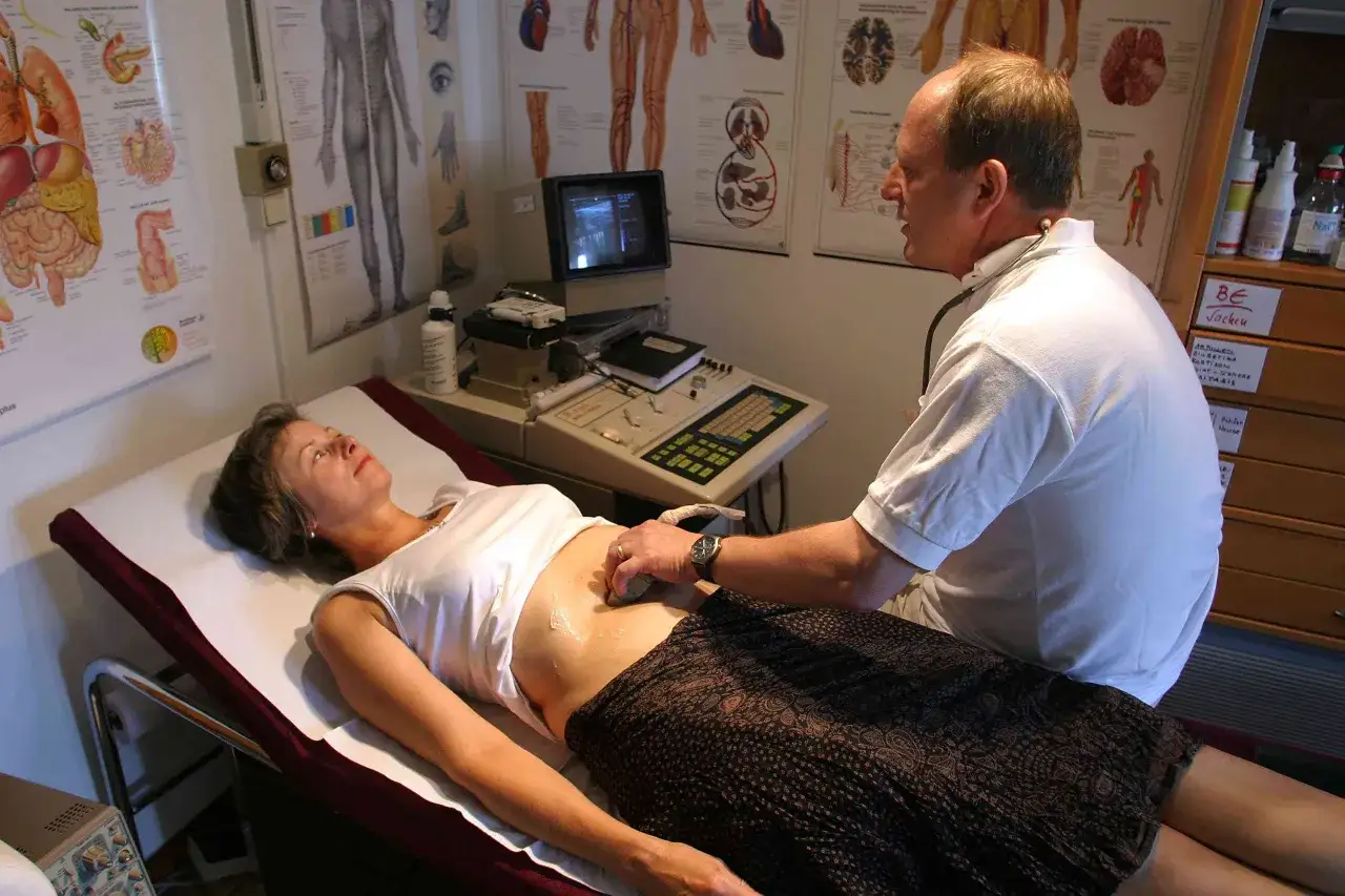 Arzt führt Ultraschalluntersuchung am Bauch einer Frau durch, um mögliche eierstockkrebs symptome abzuklären.