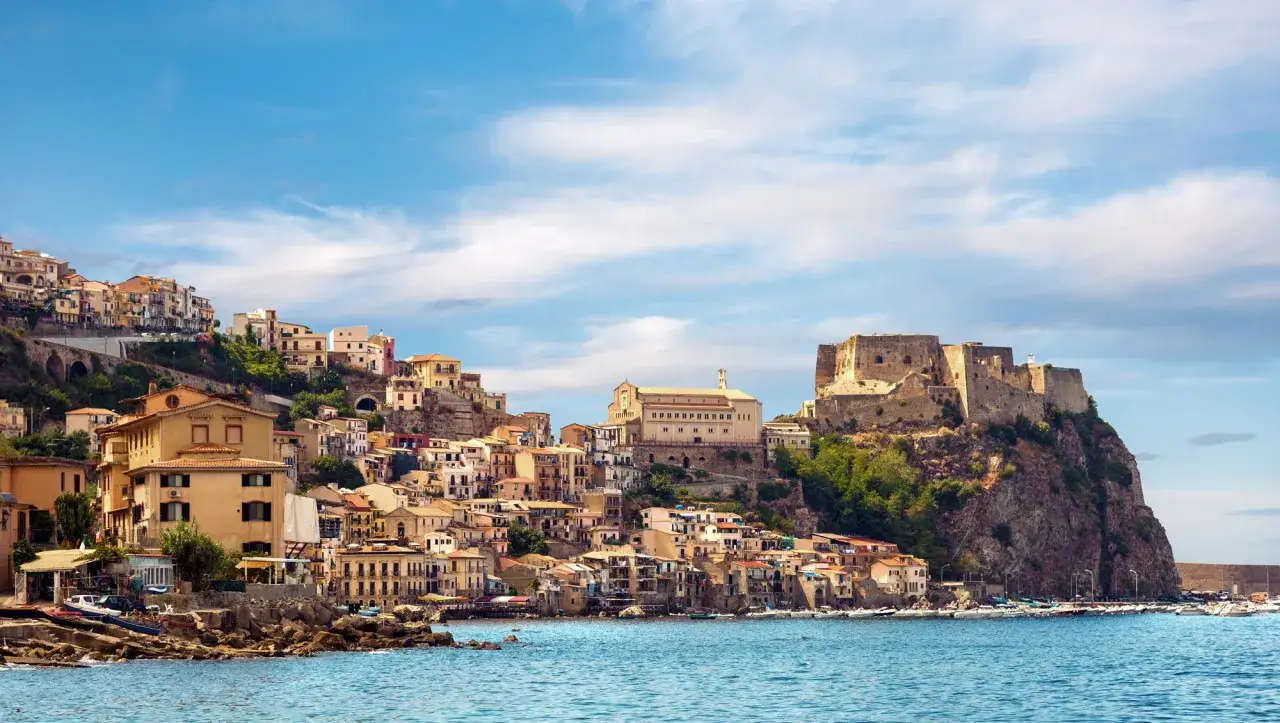 Scilla, con le sue case colorate aggrappate alla roccia, domina il mare. In alto, maestoso, il castello Ruffo domina il panorama.