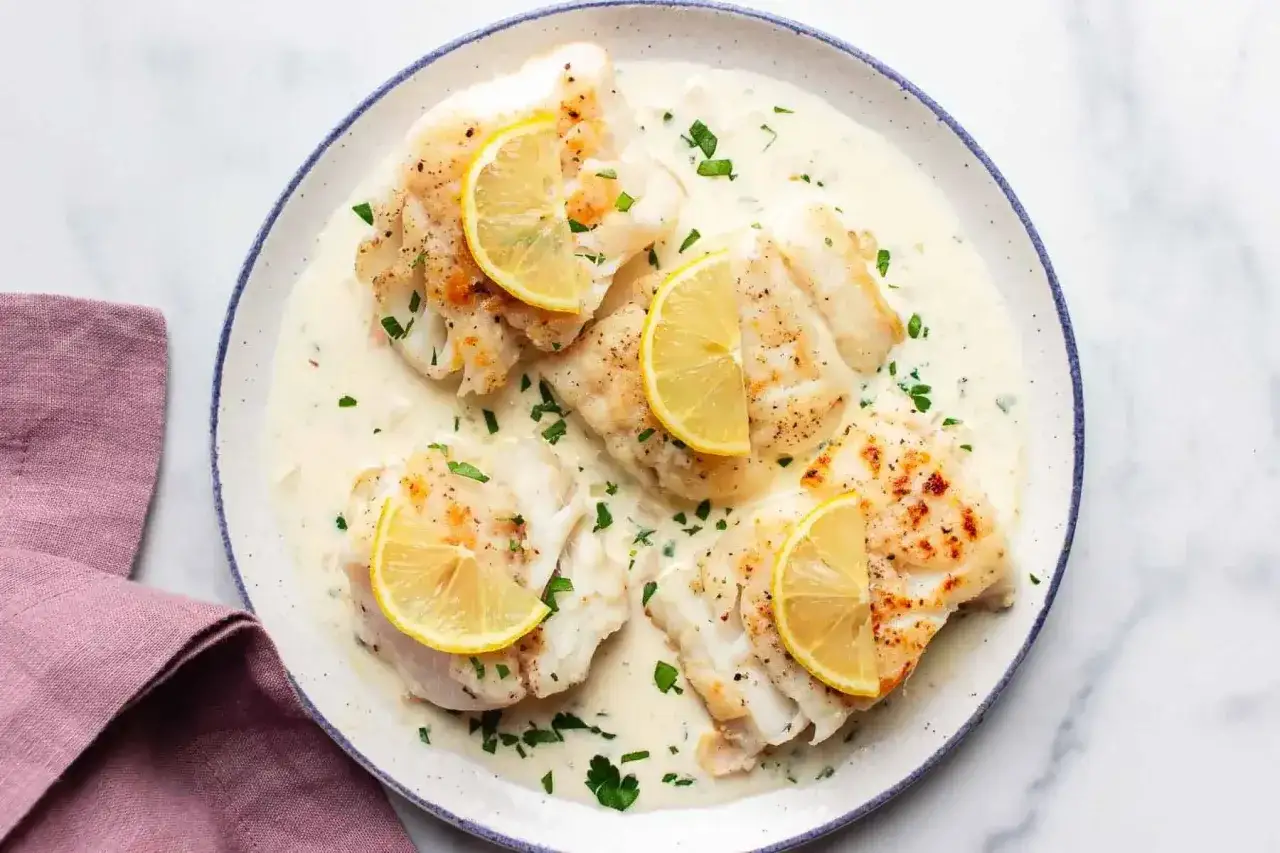 Fiskfiléer i krämig vitvinssås, toppade med citronskivor och färsk persilja. En klassisk rätt som passar perfekt till fisk.