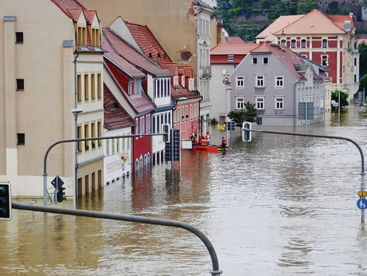 Miasto zalane wodą, widoczne budynki i łódź ratunkowa. To przerażające skutki ocieplenia klimatu.