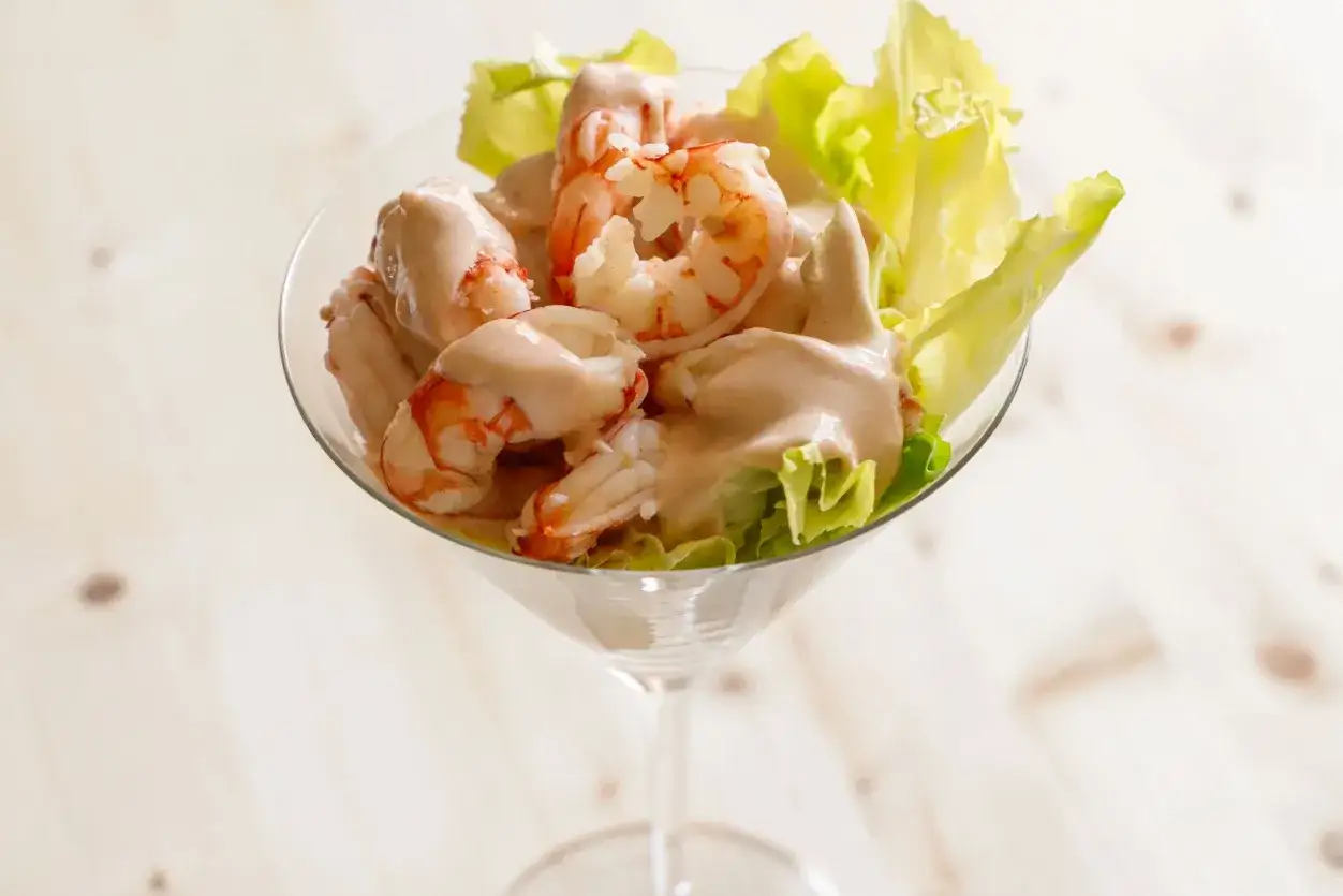 Gamberetti in salsa rosa, un antipasto fresco e gustoso servito in una coppa, con foglie di lattuga croccante.