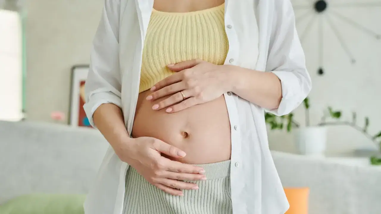 Kobieta w ciąży delikatnie obejmuje brzuch. Warto pamiętać o bezpiecznych lekach przeciwb&oacute;lowych w ciąży.