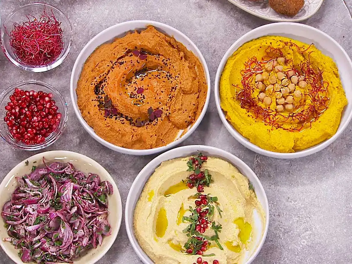 F&auml;rgglad hummus i sk&aring;lar, perfekt f&ouml;r ett hummus recept. Serveras med granat&auml;pple, kik&auml;rtor och r&ouml;dl&ouml;k.