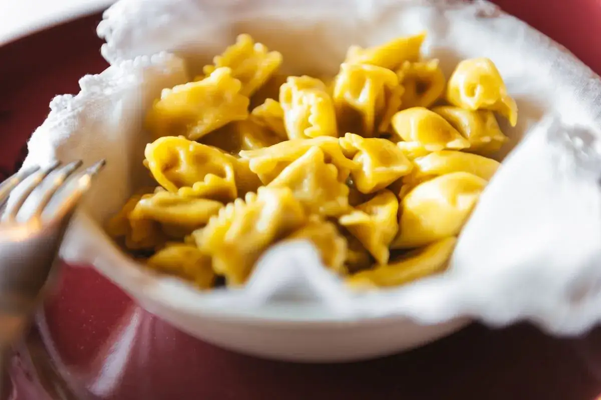 Un piatto colmo di ravioli del plin, dorati e invitanti, pronti per essere gustati.