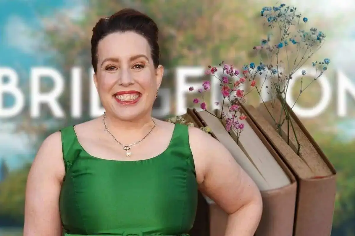 Julia Quinn sorride, con libri e fiori colorati sullo sfondo, un omaggio alle sue storie.