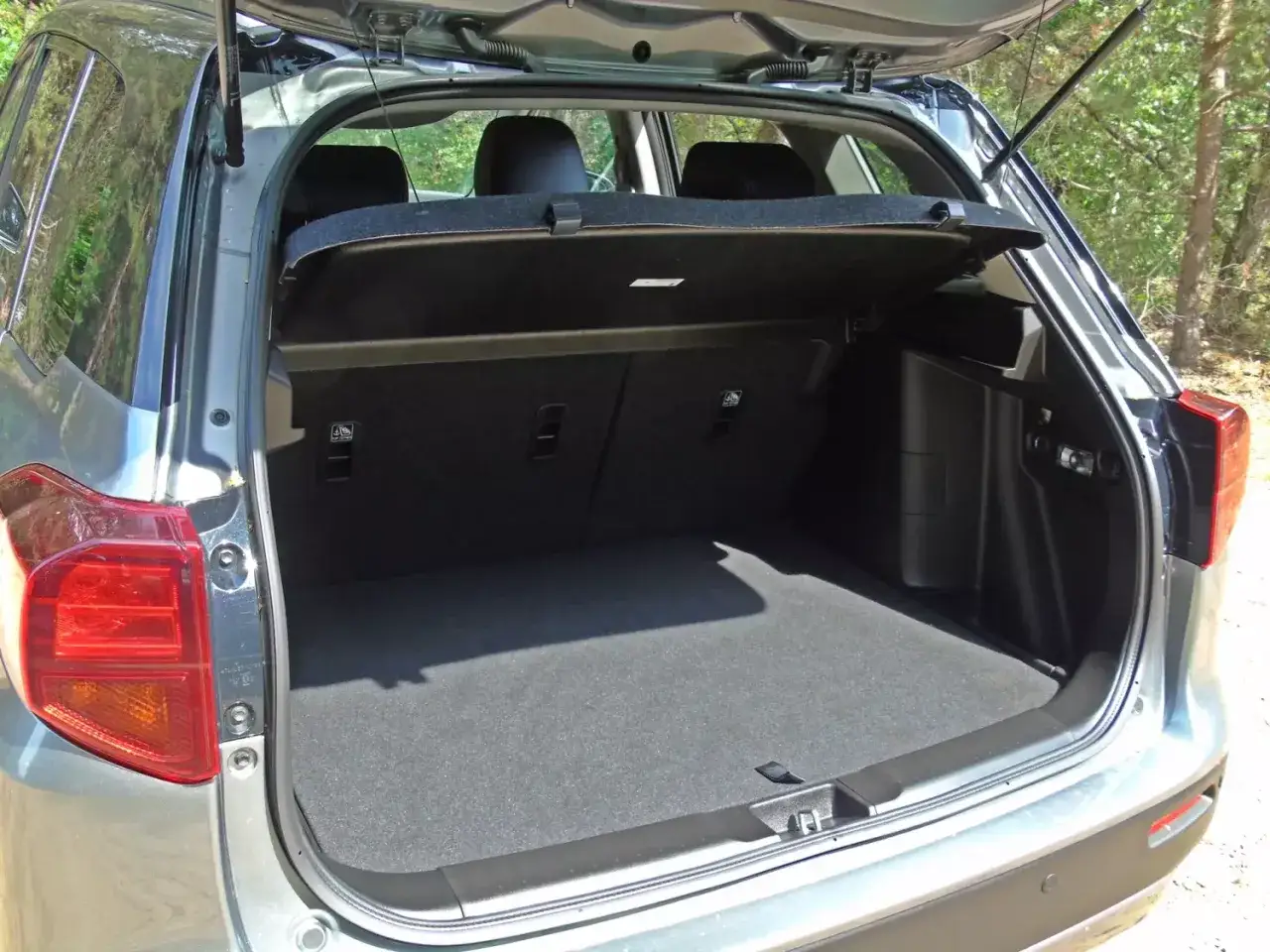 Otwarty bagażnik Suzuki Vitara Hybrid, gotowy na wakacyjne wyjazdy.