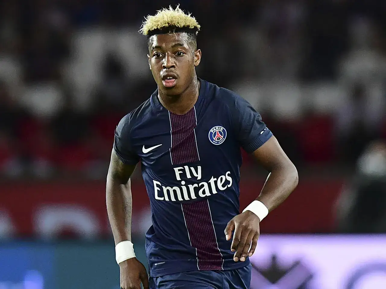 Piłkarz PSG, Kimpembe, w ciemnym stroju z logo Fly Emirates.