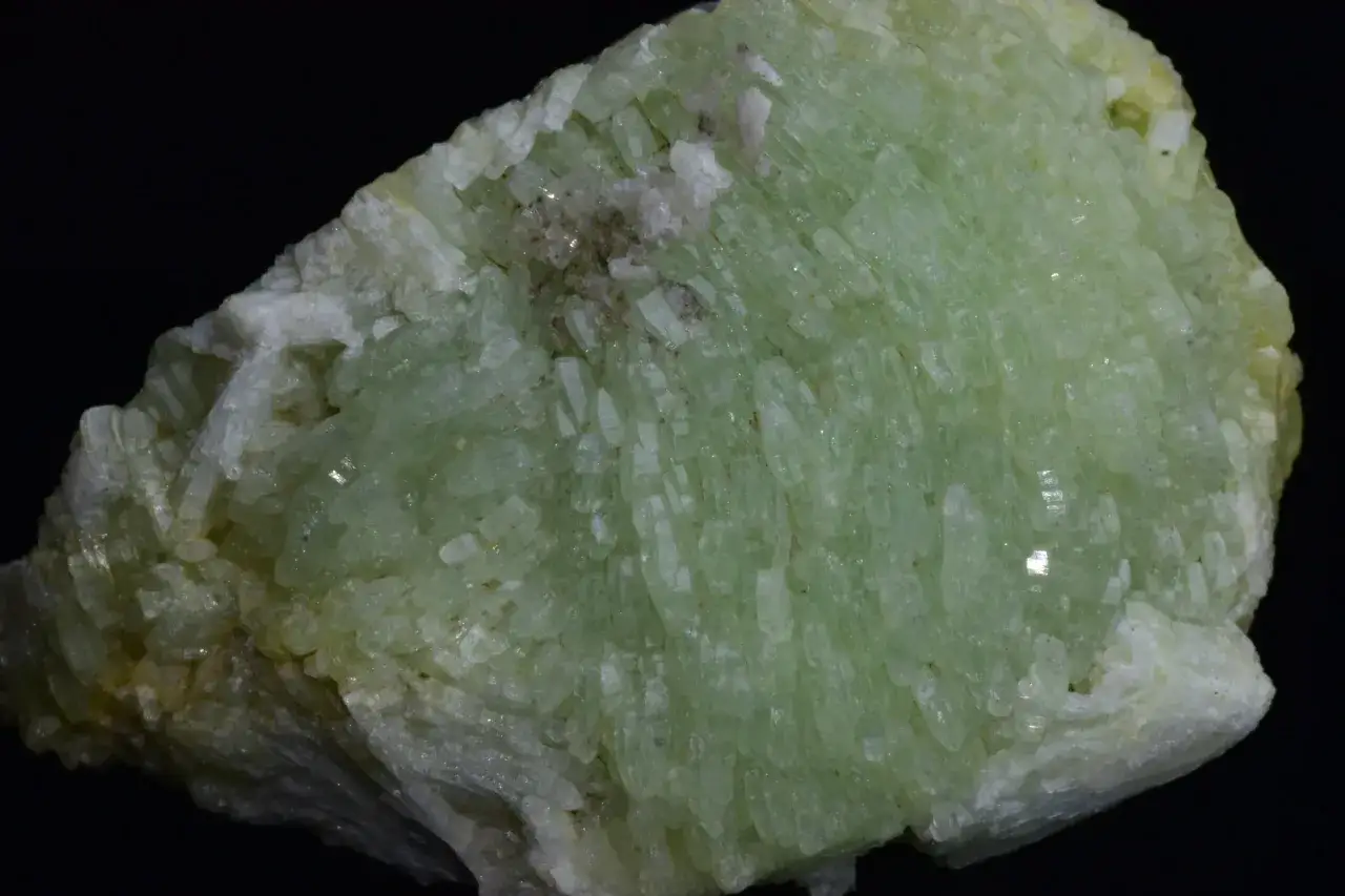 En kluster av ljusgröna kristaller med en matt yta, som visar prehnit egenskaper.