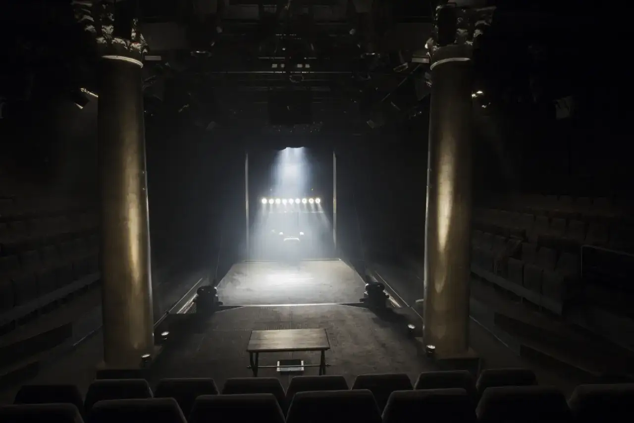 Pusta scena w teatrze stu reflektorów, gotowa na spektakl.
