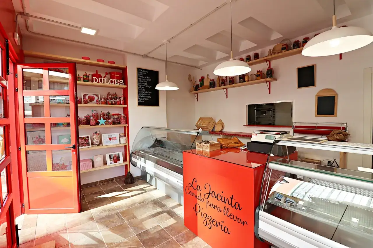 Interior de una pizzería con estanterías de dulces y vitrinas. La tasación de locales comerciales es clave para negocios como este.