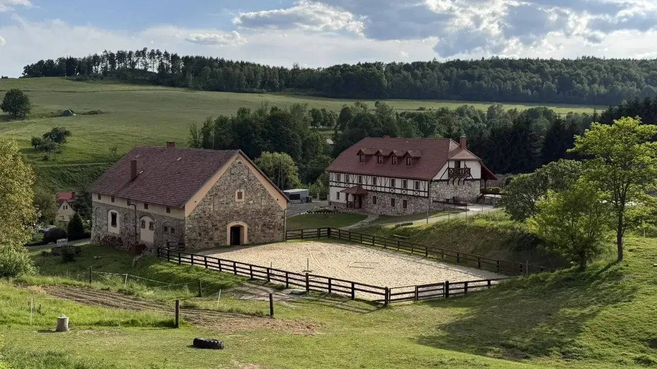 Malowniczy krajobraz z budynkami i ujeżdżalnią koni. Idealne miejsce na agroturystykę Dolny Śląsk.