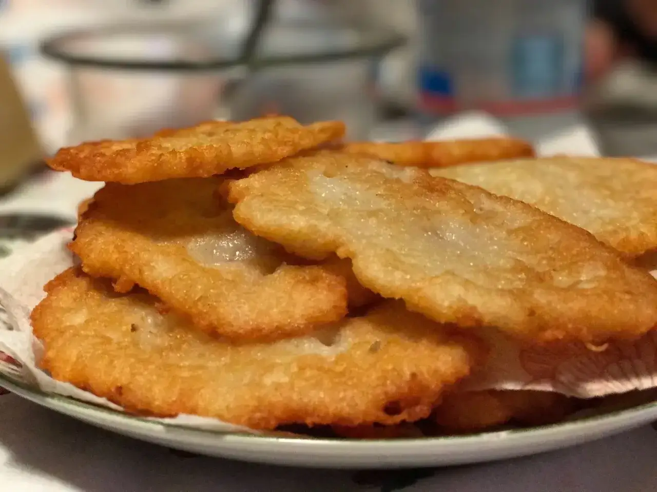 Piatto di tortel di patate dorati e croccanti, impilati su un tovagliolo.