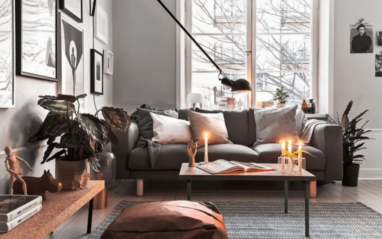 Mysig vardagsrumsmiljö med soffa, kuddar, ljus och växter. Perfekt inspiration för din blogg inredning.
