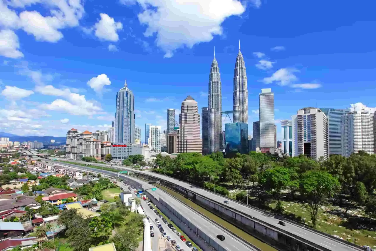 Widok na drapacze chmur w Kuala Lumpur, w tym słynne bliźniacze wieże Petronas. Idealny czas na zwiedzanie, kiedy najlepiej lecieć do Kuala Lumpur, to okres od czerwca do września.